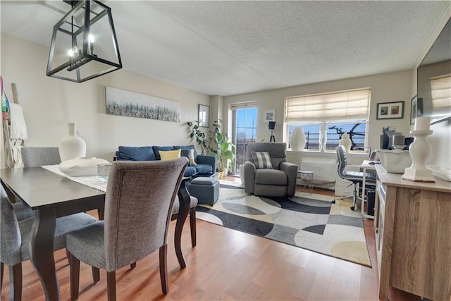 dining space with a textured ceiling and wood finished floors