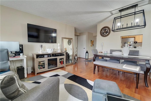 living area featuring a textured ceiling, wood finished floors, and lofted ceiling