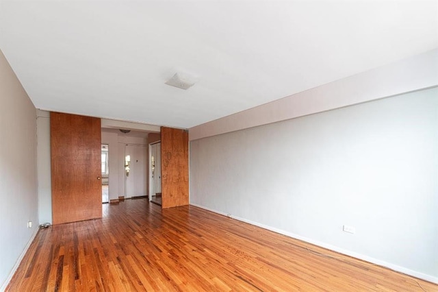 empty room featuring wood finished floors and baseboards