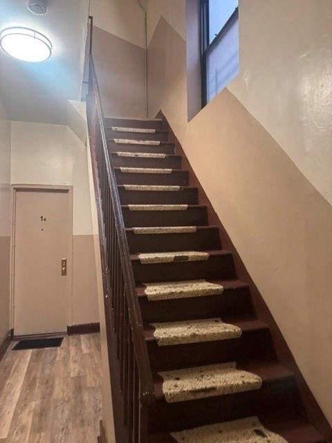 stairs featuring a high ceiling and wood finished floors