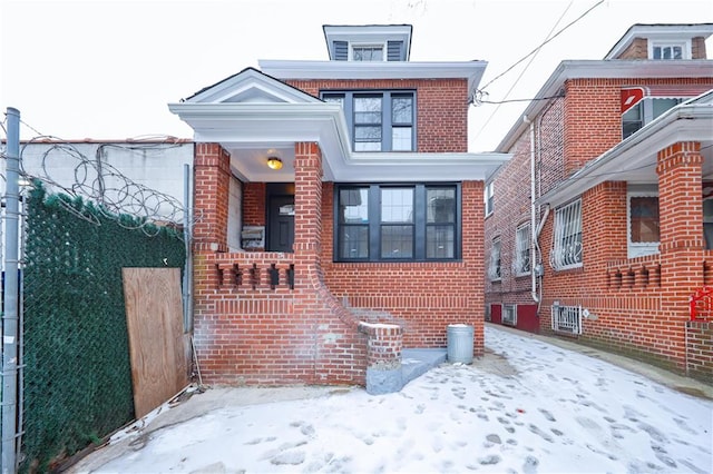 view of front of home with brick siding and fence