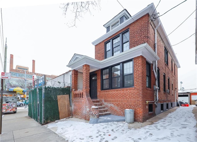 traditional style home featuring brick siding and fence