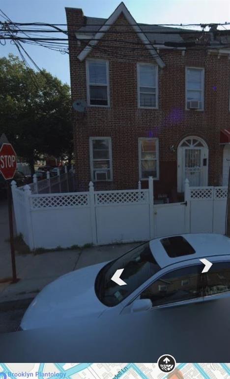 view of front facade with brick siding and a fenced front yard