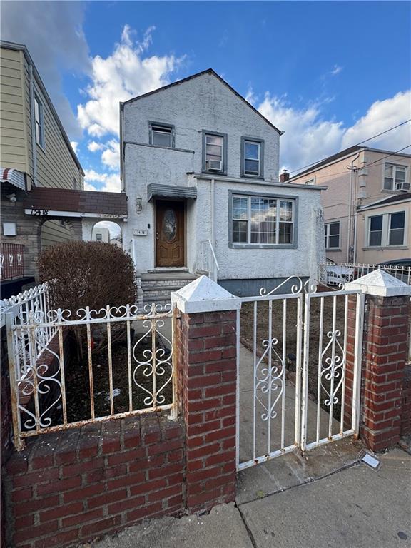 view of front of property featuring a fenced front yard and a gate