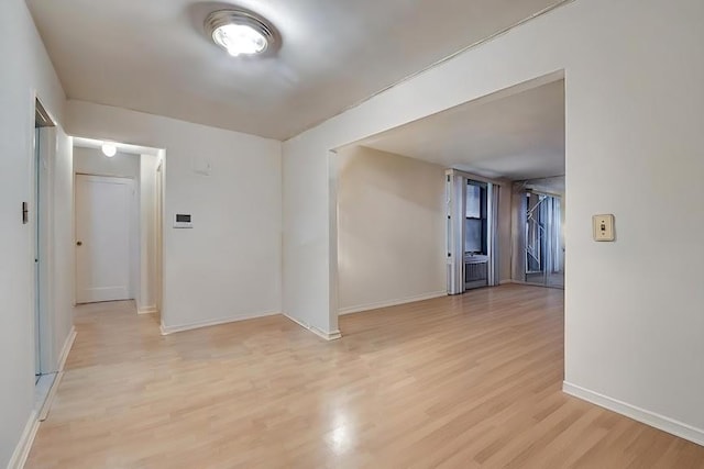 spare room featuring light wood finished floors and baseboards