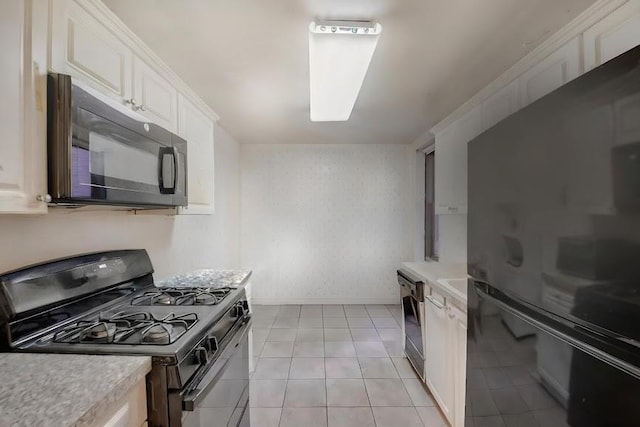 kitchen with light countertops, black appliances, and white cabinetry