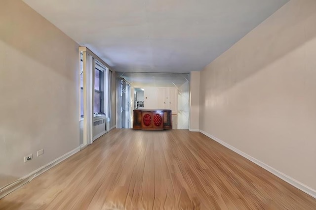 unfurnished living room featuring light wood finished floors and baseboards