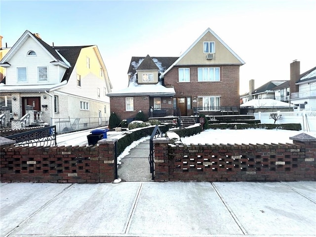 view of front facade with a fenced front yard, a residential view, and brick siding