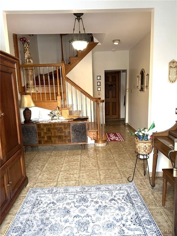 foyer entrance featuring light tile patterned floors and stairway