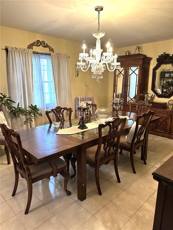 dining space featuring a chandelier and light tile patterned floors