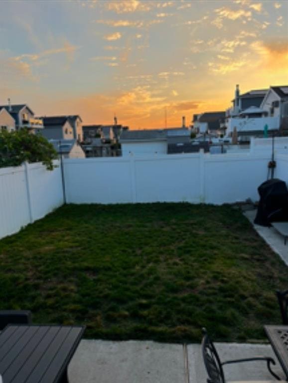 yard at dusk with a fenced backyard