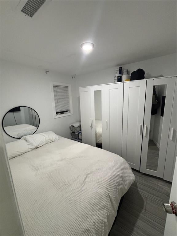 bedroom featuring dark wood finished floors and visible vents