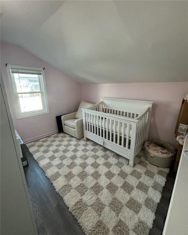 bedroom with baseboards and lofted ceiling