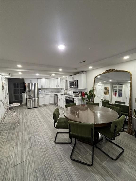 dining area featuring recessed lighting, arched walkways, and light carpet