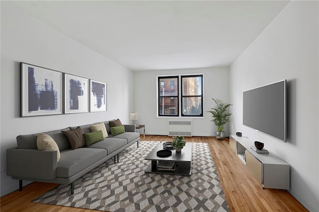 living area with radiator heating unit and light wood-type flooring