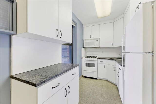 9902 3rd Ave Unit 1M, Brooklyn, NY 11209 - kitchen with white appliances, white cabinetry, a sink, light tile patterned floors, and dark stone countertops