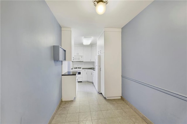 hall featuring light tile patterned floors and baseboards