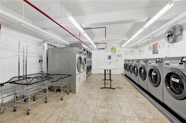 common laundry area with washing machine and clothes dryer and tile patterned floors