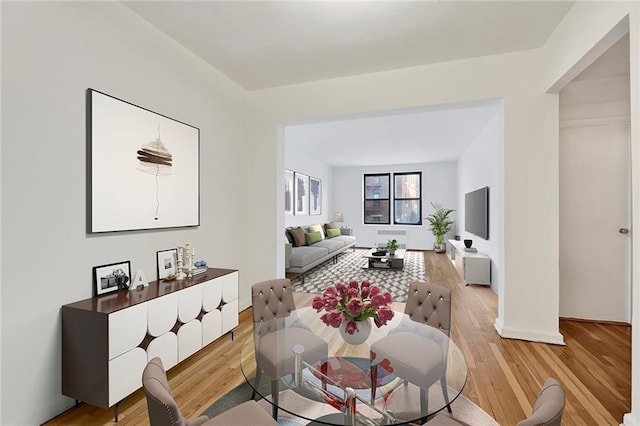 dining area featuring light wood-type flooring and baseboards