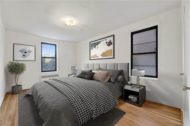 bedroom with light wood-style floors and radiator