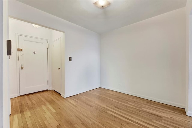 unfurnished room with baseboards and light wood finished floors
