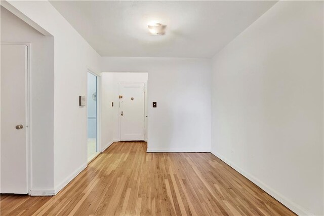 hall featuring baseboards and light wood finished floors