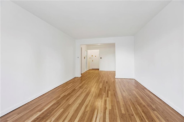 spare room with light wood-style floors and baseboards