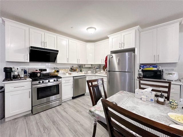 kitchen featuring stainless steel appliances, light wood-type flooring, white cabinets, and light countertops