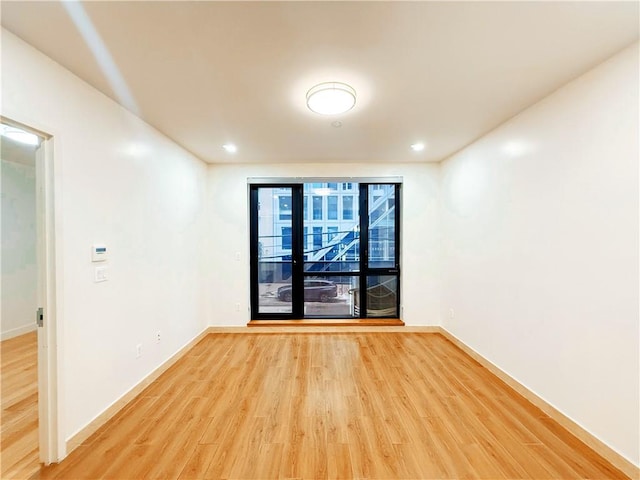 unfurnished room with baseboards and wood finished floors