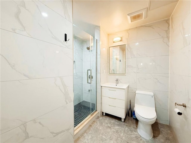 bathroom with toilet, tile walls, vanity, and a shower with door