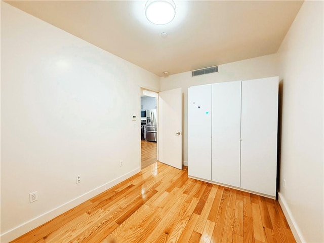 42-22 Crescent St Unit 2C, Long Island City, NY 11101 - unfurnished bedroom featuring stainless steel fridge with ice dispenser, light wood-type flooring, and a closet