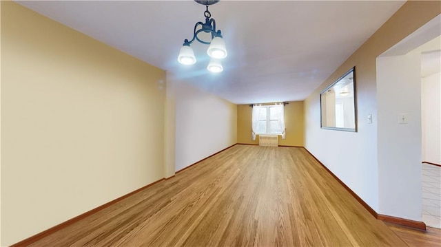 spare room featuring hardwood / wood-style flooring and radiator heating unit