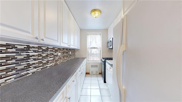 2525 Nostrand Ave Unit 3R, Brooklyn, NY 11210 - kitchen featuring radiator heating unit, freestanding refrigerator, black gas range, stainless steel microwave, and white cabinets