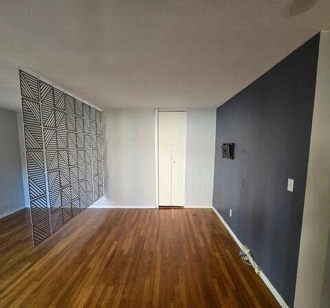 unfurnished bedroom with dark wood-type flooring