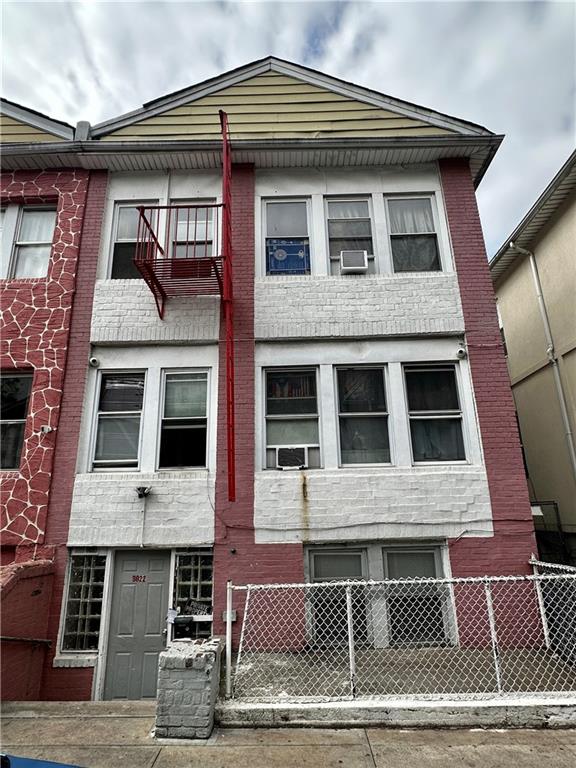 multi unit property featuring brick siding and a fenced front yard