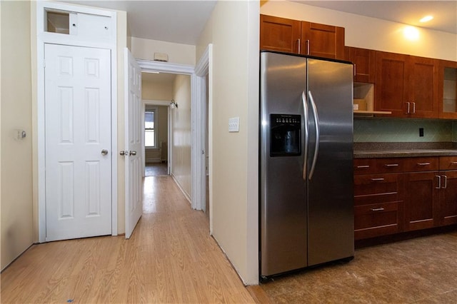 kitchen featuring tasteful backsplash, light wood-type flooring, and stainless steel refrigerator with ice dispenser