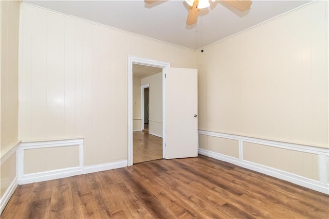 empty room featuring hardwood / wood-style flooring, crown molding, and ceiling fan