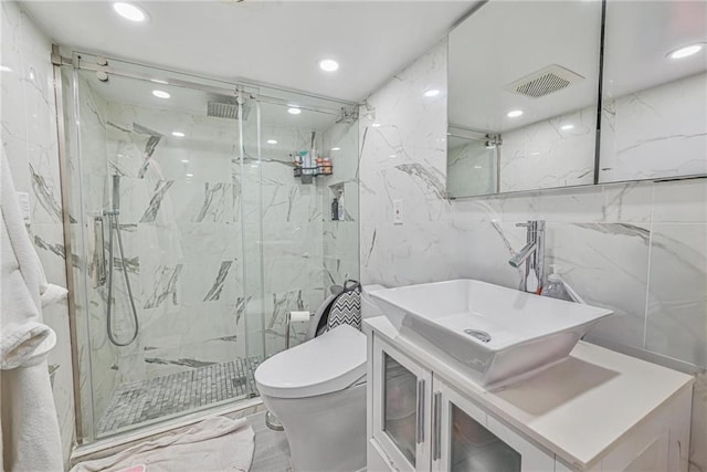 bathroom with walk in shower, vanity, toilet, and tile walls