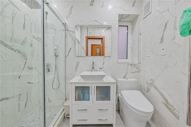 bathroom with toilet, tile walls, vanity, and a shower with shower door