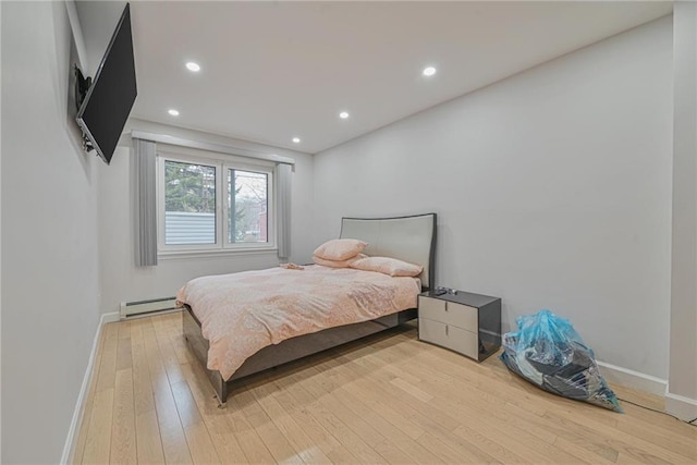 bedroom featuring light hardwood / wood-style flooring and a baseboard radiator