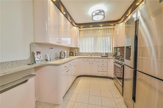 kitchen with light tile patterned flooring, sink, white cabinetry, appliances with stainless steel finishes, and decorative backsplash