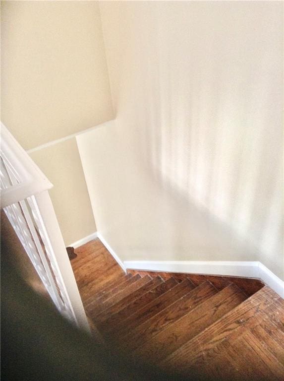 stairway with baseboards and wood finished floors