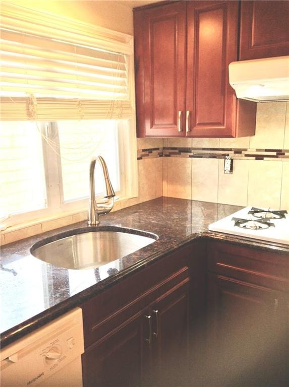 kitchen with reddish brown cabinets, decorative backsplash, a sink, ventilation hood, and white appliances