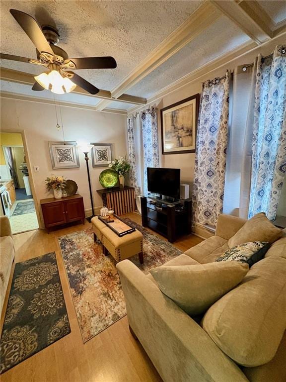 living room featuring coffered ceiling, light hardwood / wood-style floors, crown molding, a textured ceiling, and beam ceiling