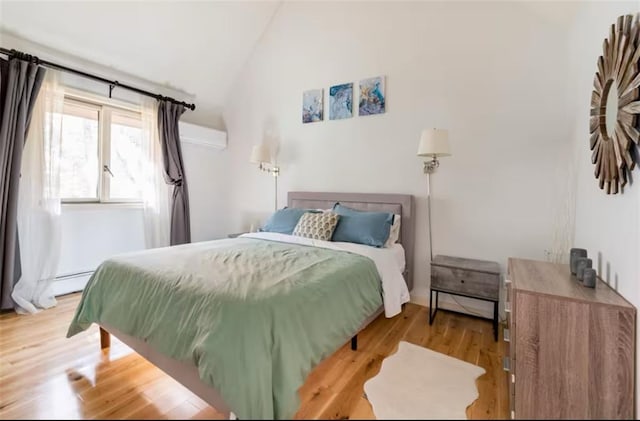 bedroom with lofted ceiling and light hardwood / wood-style flooring