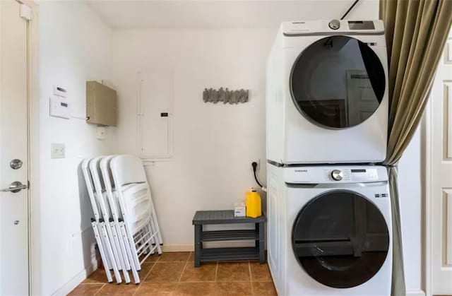 clothes washing area featuring stacked washing maching and dryer, electric panel, and tile patterned floors