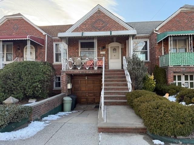 view of front facade with concrete driveway, brick siding, and an attached garage