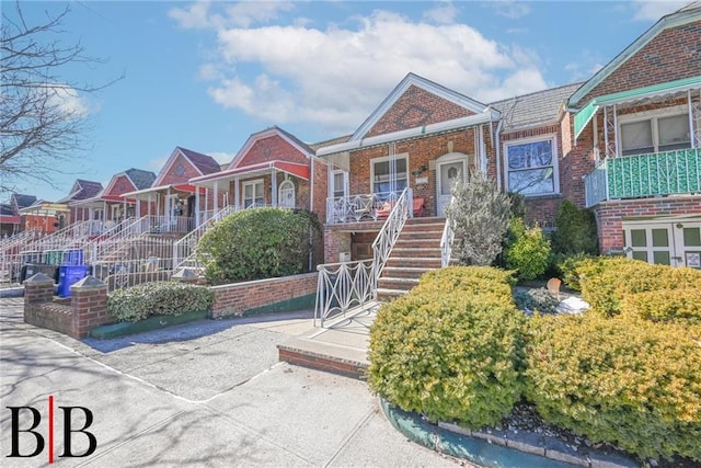 view of front of property featuring stairway and brick siding