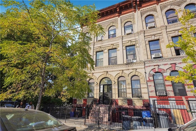 view of building exterior with a fenced front yard and cooling unit