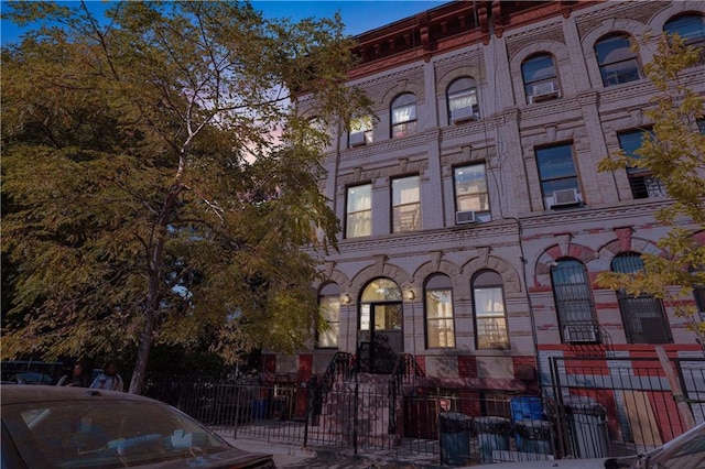 view of building exterior featuring a fenced front yard and cooling unit